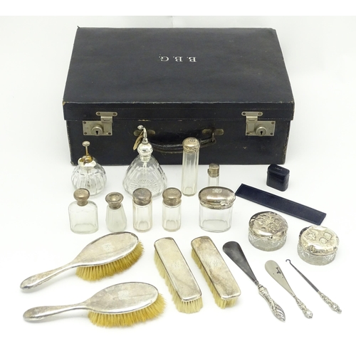 513 - A blue leather vanity case / valise containing a quantity of assorted silver topped bottles, jars, s... 