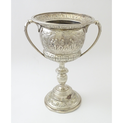 520 - A late 19th / early 20thC silver plate football trophy cup with twin handles and footballer detail. ... 