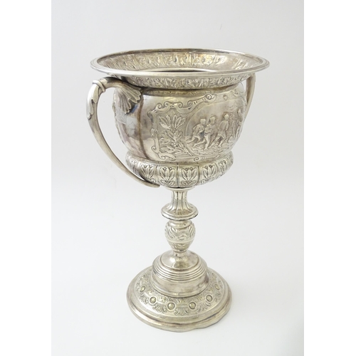 520 - A late 19th / early 20thC silver plate football trophy cup with twin handles and footballer detail. ... 