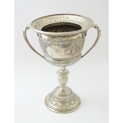 520 - A late 19th / early 20thC silver plate football trophy cup with twin handles and footballer detail. ... 