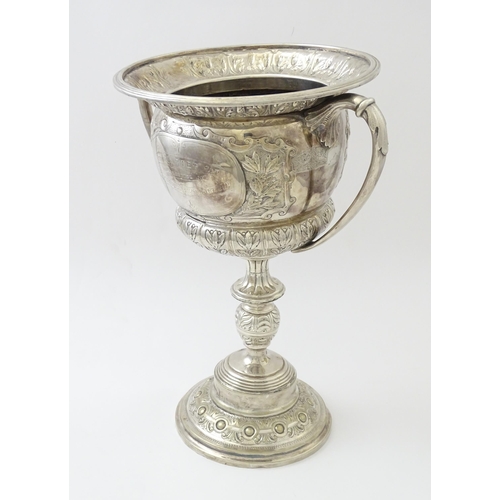 520 - A late 19th / early 20thC silver plate football trophy cup with twin handles and footballer detail. ... 