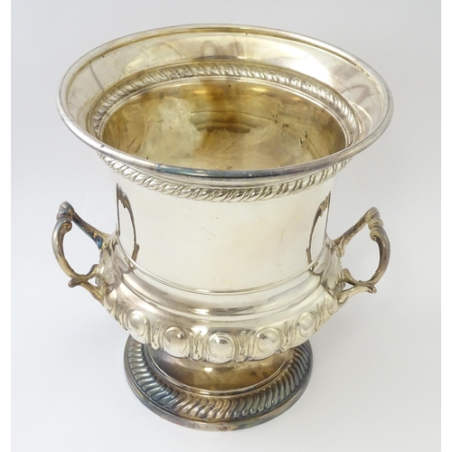 521 - A silver plate wine cooler of twin handled campana urn form. Approx. 10