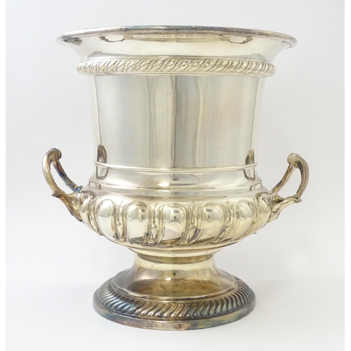 521 - A silver plate wine cooler of twin handled campana urn form. Approx. 10