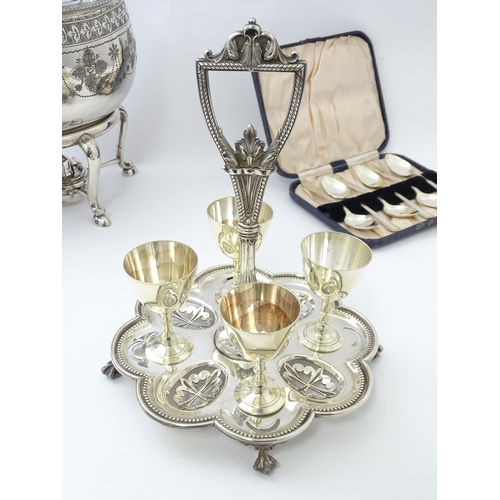 527 - A quantity of silver plated wares to include egg cruet, kettle on stand, spoons, bottle coaster etc.... 