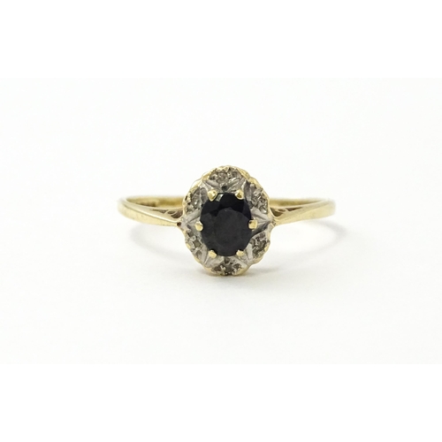 539 - A 9ct gold ring set with central sapphire bordered by diamonds. Ring size approx. M 1/2