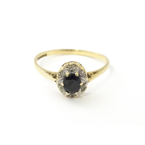 539 - A 9ct gold ring set with central sapphire bordered by diamonds. Ring size approx. M 1/2