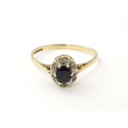 539 - A 9ct gold ring set with central sapphire bordered by diamonds. Ring size approx. M 1/2