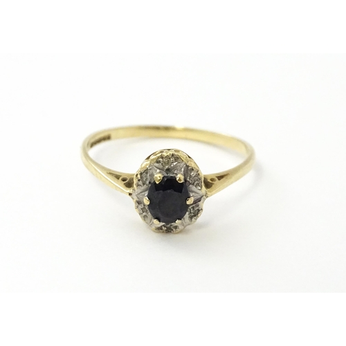 539 - A 9ct gold ring set with central sapphire bordered by diamonds. Ring size approx. M 1/2