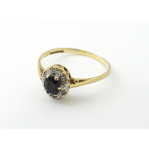 539 - A 9ct gold ring set with central sapphire bordered by diamonds. Ring size approx. M 1/2