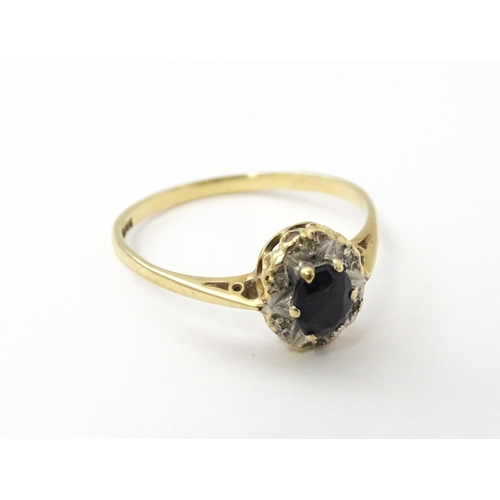 539 - A 9ct gold ring set with central sapphire bordered by diamonds. Ring size approx. M 1/2