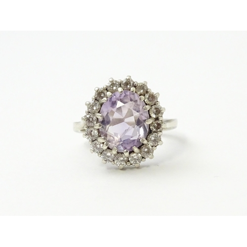 576 - A silver ring set with amethyst and white stones. Ring size approx. N1/2