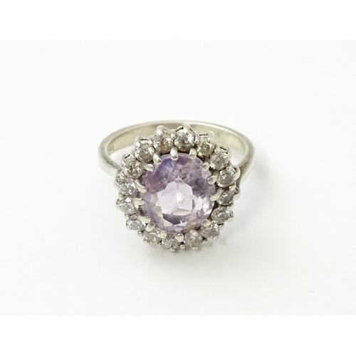 576 - A silver ring set with amethyst and white stones. Ring size approx. N1/2