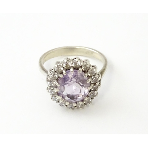 576 - A silver ring set with amethyst and white stones. Ring size approx. N1/2