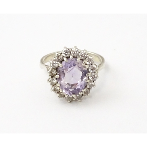 576 - A silver ring set with amethyst and white stones. Ring size approx. N1/2