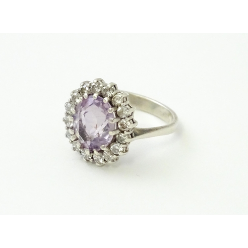 576 - A silver ring set with amethyst and white stones. Ring size approx. N1/2