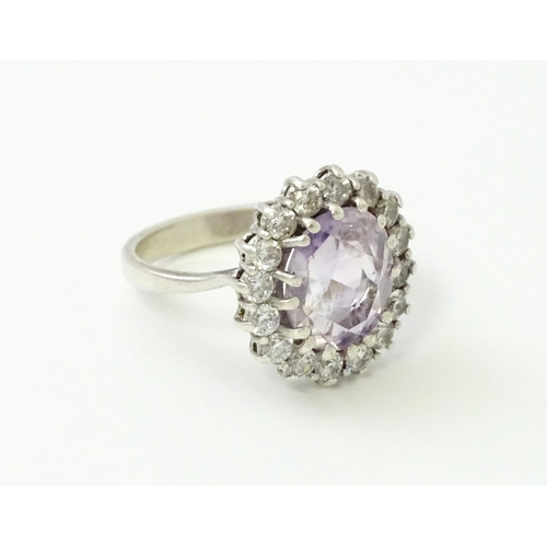 576 - A silver ring set with amethyst and white stones. Ring size approx. N1/2