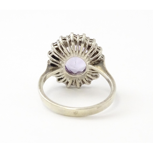 576 - A silver ring set with amethyst and white stones. Ring size approx. N1/2