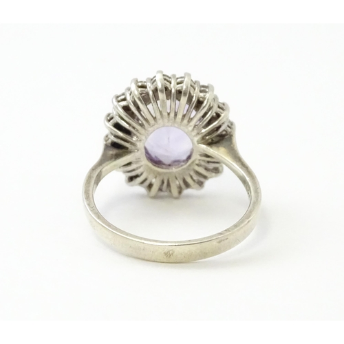 576 - A silver ring set with amethyst and white stones. Ring size approx. N1/2