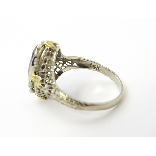 578 - A 14k gold ring set with central amethyst and seed pearls with filigree style detail. Ring size appr... 