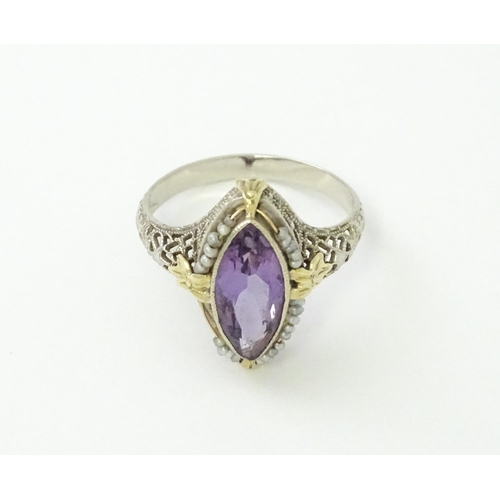 578 - A 14k gold ring set with central amethyst and seed pearls with filigree style detail. Ring size appr... 