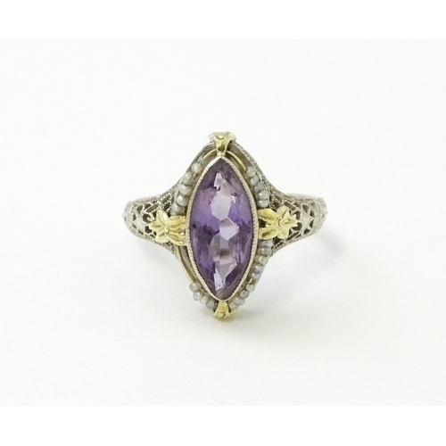 578 - A 14k gold ring set with central amethyst and seed pearls with filigree style detail. Ring size appr... 