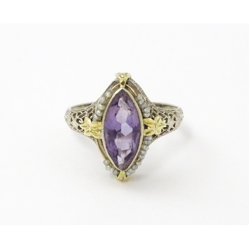 578 - A 14k gold ring set with central amethyst and seed pearls with filigree style detail. Ring size appr... 