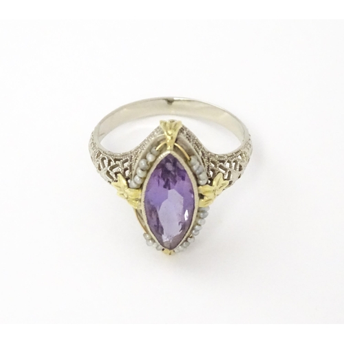 578 - A 14k gold ring set with central amethyst and seed pearls with filigree style detail. Ring size appr... 