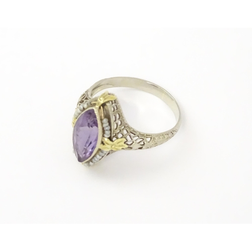 578 - A 14k gold ring set with central amethyst and seed pearls with filigree style detail. Ring size appr... 