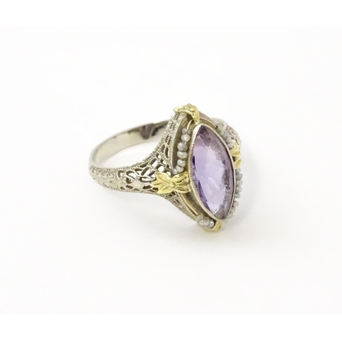 578 - A 14k gold ring set with central amethyst and seed pearls with filigree style detail. Ring size appr... 