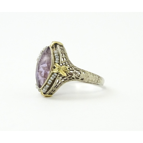 578 - A 14k gold ring set with central amethyst and seed pearls with filigree style detail. Ring size appr... 