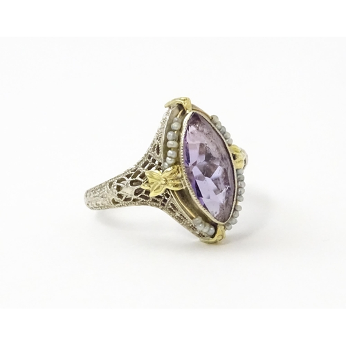 578 - A 14k gold ring set with central amethyst and seed pearls with filigree style detail. Ring size appr... 