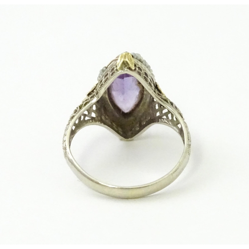 578 - A 14k gold ring set with central amethyst and seed pearls with filigree style detail. Ring size appr... 