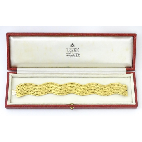 581 - An 18ct gold bracelet formed as eight rows, with textured chevron pattern, box snap clasp and safety... 