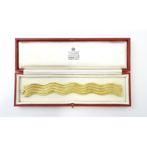 581 - An 18ct gold bracelet formed as eight rows, with textured chevron pattern, box snap clasp and safety... 