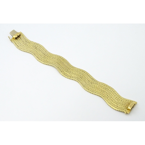 581 - An 18ct gold bracelet formed as eight rows, with textured chevron pattern, box snap clasp and safety... 