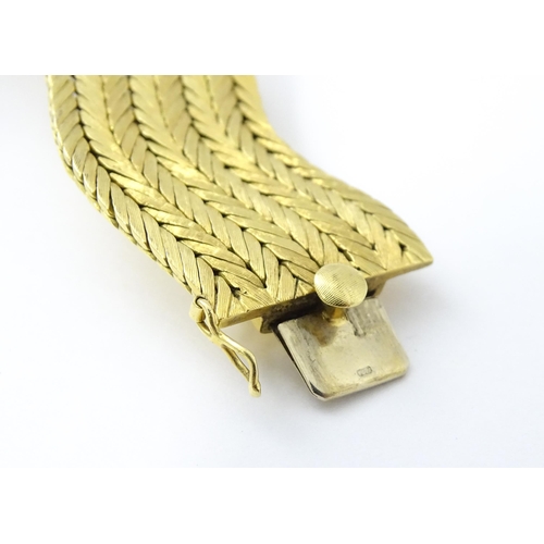 581 - An 18ct gold bracelet formed as eight rows, with textured chevron pattern, box snap clasp and safety... 