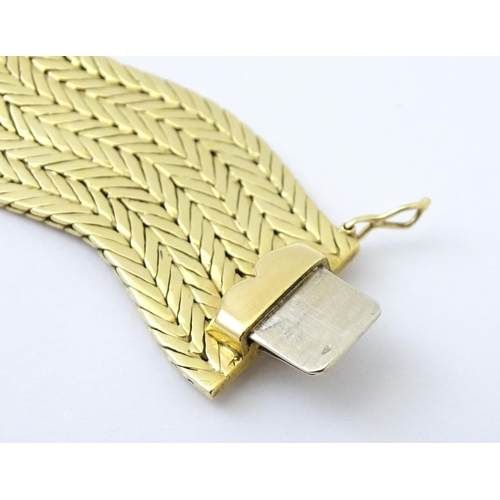 581 - An 18ct gold bracelet formed as eight rows, with textured chevron pattern, box snap clasp and safety... 