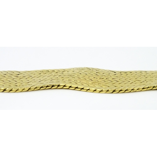 581 - An 18ct gold bracelet formed as eight rows, with textured chevron pattern, box snap clasp and safety... 