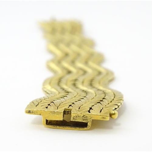 581 - An 18ct gold bracelet formed as eight rows, with textured chevron pattern, box snap clasp and safety... 