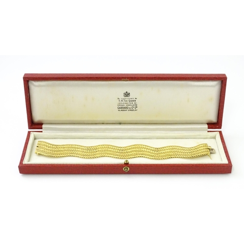 581 - An 18ct gold bracelet formed as eight rows, with textured chevron pattern, box snap clasp and safety... 