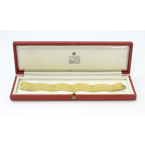 581 - An 18ct gold bracelet formed as eight rows, with textured chevron pattern, box snap clasp and safety... 