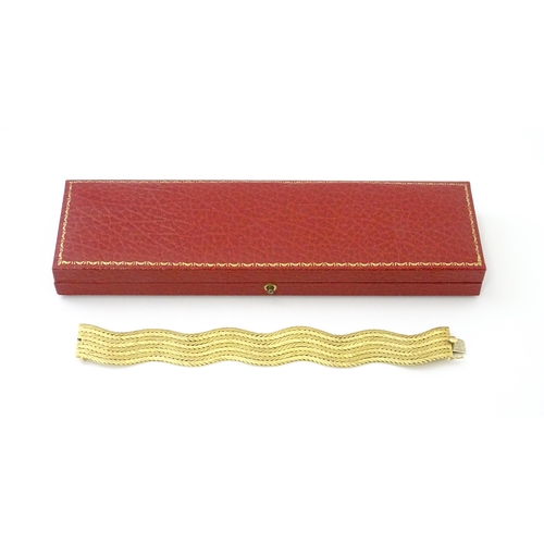 581 - An 18ct gold bracelet formed as eight rows, with textured chevron pattern, box snap clasp and safety... 