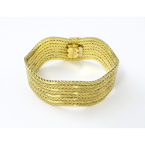 581 - An 18ct gold bracelet formed as eight rows, with textured chevron pattern, box snap clasp and safety... 