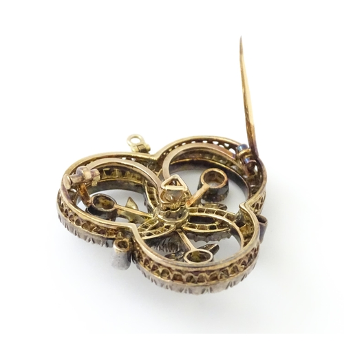 583 - A yellow gold brooch / pendant of trefoil form set with a profusion of diamonds with floral detail. ... 