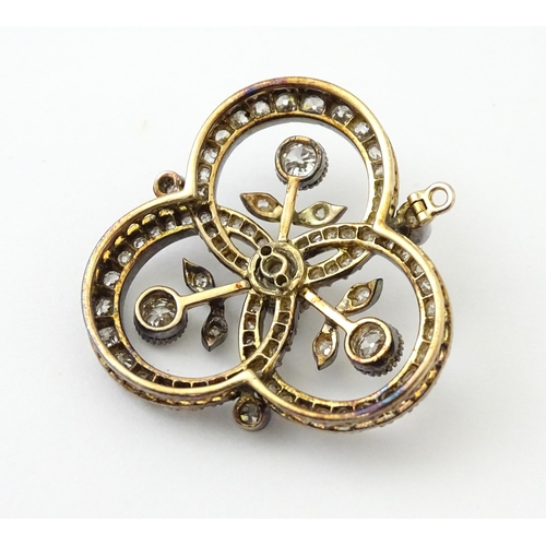 583 - A yellow gold brooch / pendant of trefoil form set with a profusion of diamonds with floral detail. ... 