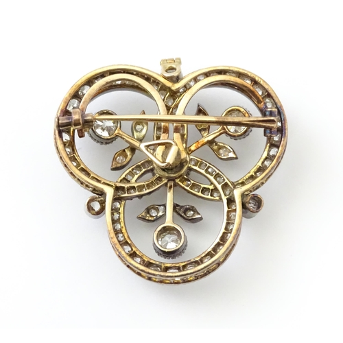 583 - A yellow gold brooch / pendant of trefoil form set with a profusion of diamonds with floral detail. ... 