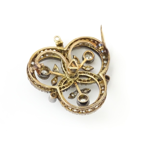 583 - A yellow gold brooch / pendant of trefoil form set with a profusion of diamonds with floral detail. ... 