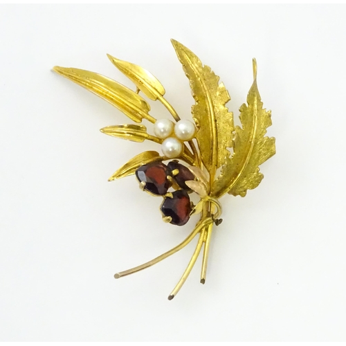 584 - A 9ct gold brooch of foliate form set with garnets and pearls. Approx. 2