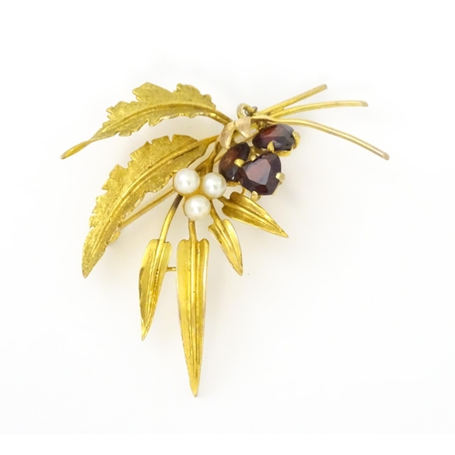 584 - A 9ct gold brooch of foliate form set with garnets and pearls. Approx. 2