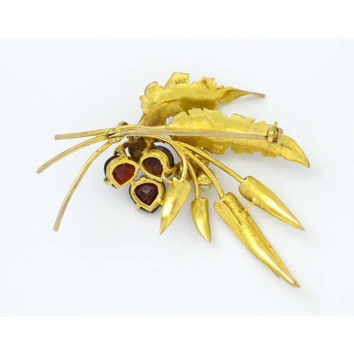 584 - A 9ct gold brooch of foliate form set with garnets and pearls. Approx. 2